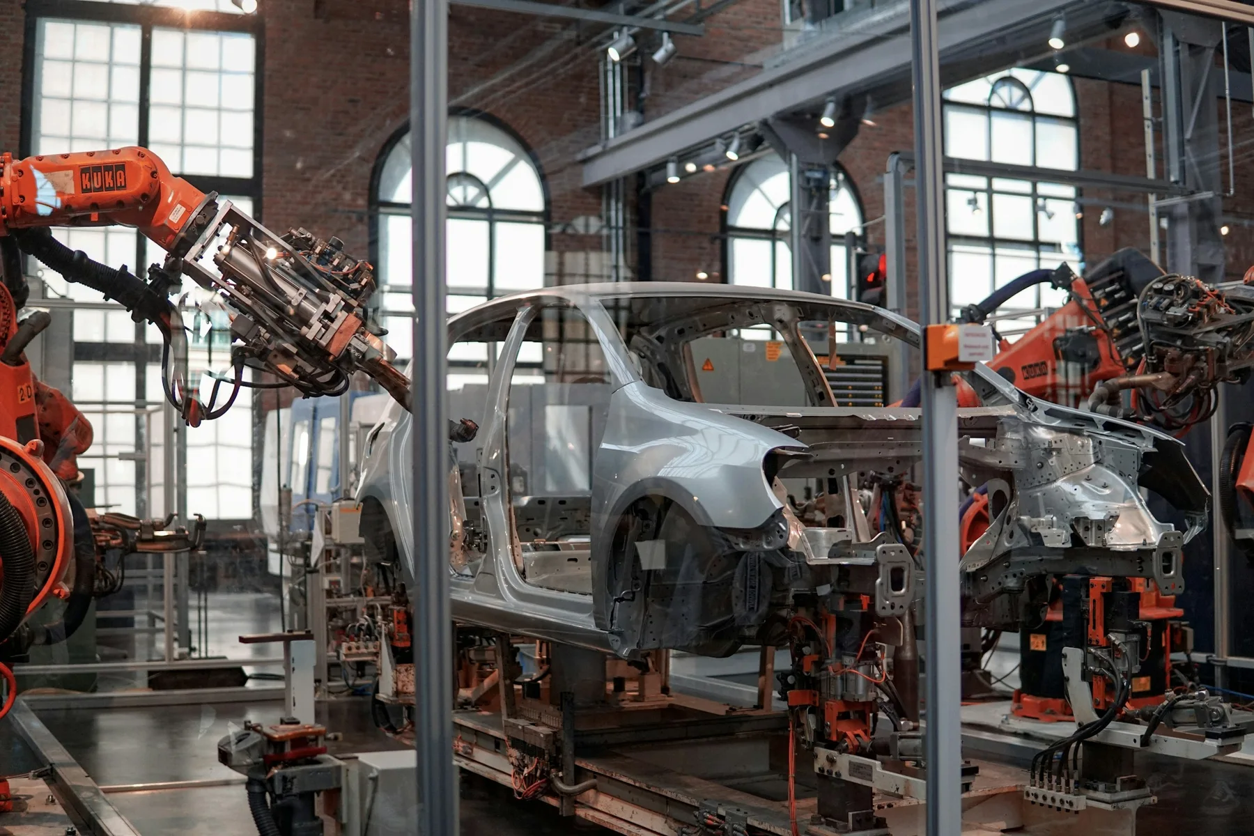 Industrial robots around a car body — illustrative industry photo